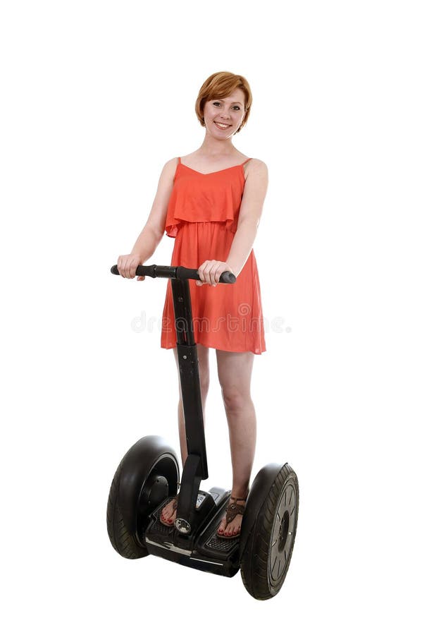 Giovane donna turistica attraente in segway elettrico sorridente di guida felice del vestito elegante da estate immagine stock libera da diritti Giovane donna turistica attraente in segway elettrico sorridente di guida felice del vestito elegante da estate immagine stock libera da diritti