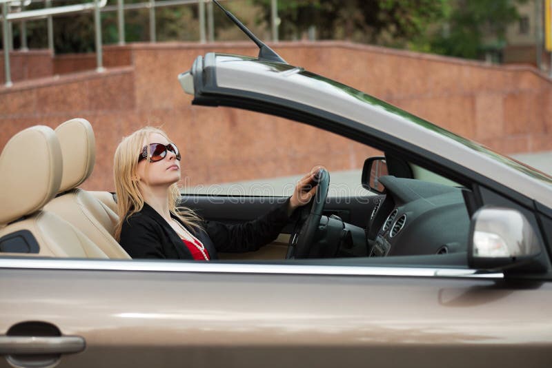 Giovane donna in un convertibile. fotografia stock Giovane donna in un convertibile. fotografia stock