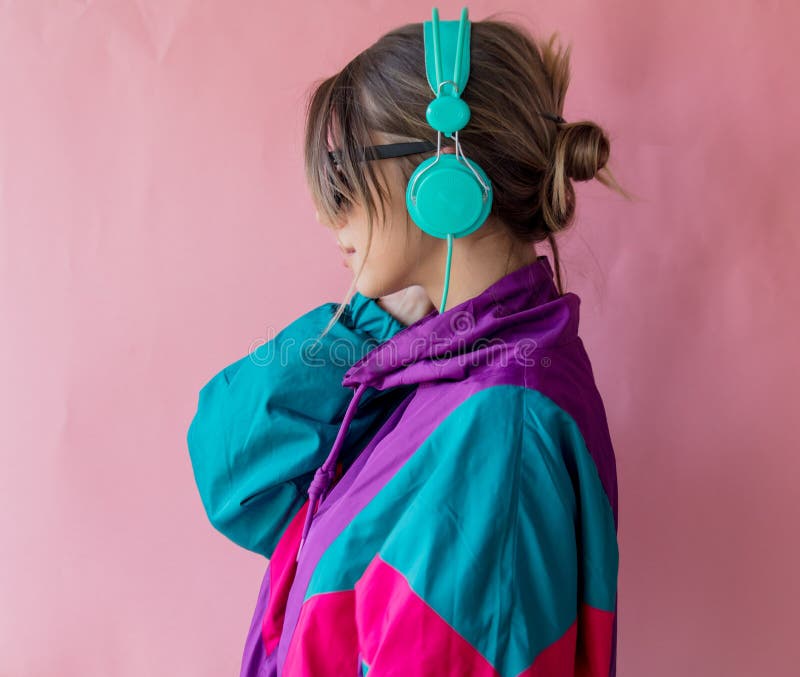 Giovane donna in vestiti di stile 90s con le cuffie fotografia stock libera da diritti Giovane donna in vestiti di stile 90s con le cuffie fotografia stock libera da diritti