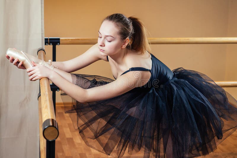 Giovane e bella donna vestita da balletto e danza a punti La ballerina si riscalda in classe La ballerina immagini stock libere da diritti Giovane e bella donna vestita da balletto e danza a punti La ballerina si riscalda in classe La ballerina immagini stock libere da diritti