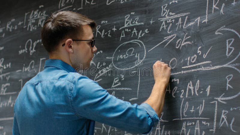 Giovane e brillante matematico si avvicina alla grande lavagna e finisce per scrivere sofisticati fotografia stock libera da diritti