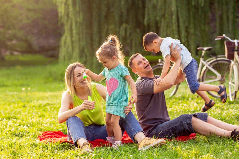 Giovane famiglia con i bambini divertendosi in natura fotografia stock Giovane famiglia con i bambini divertendosi in natura fotografia stock