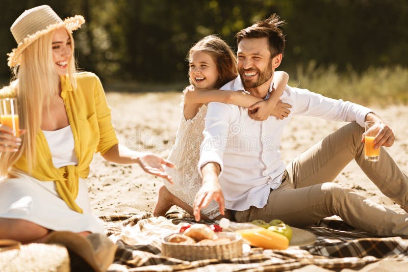 Giovane famiglia felice che gode del picnic in natura fotografia stock Giovane famiglia felice che gode del picnic in natura fotografia stock
