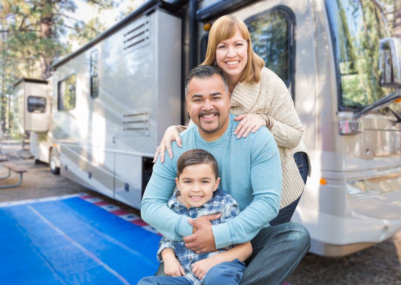 Happy Young Mixed Race Family In Front of Their Beautiful RV At The Campground. Happy Young Mixed Race Family In Front of Their Beautiful RV At The Campground.