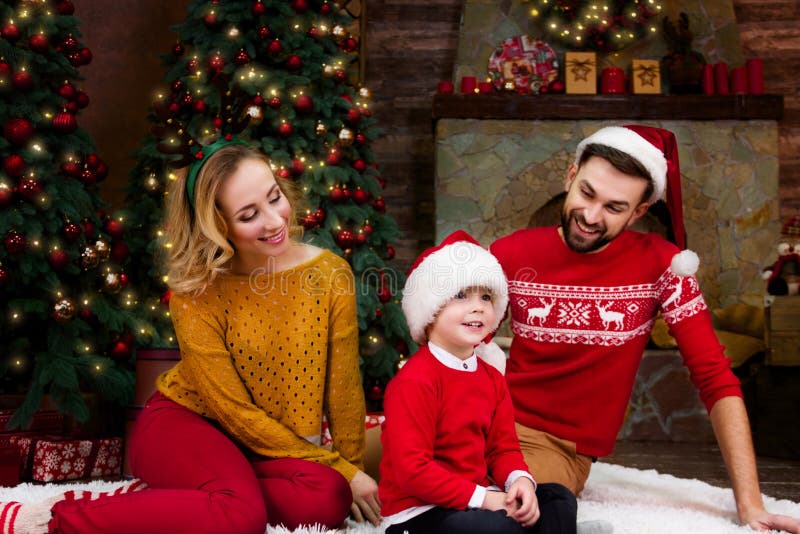 Giovane famiglia felice durante le feste del buon anno e di Buon Natale fotografia stock libera da diritti Giovane famiglia felice durante le feste del buon anno e di Buon Natale fotografia stock libera da diritti
