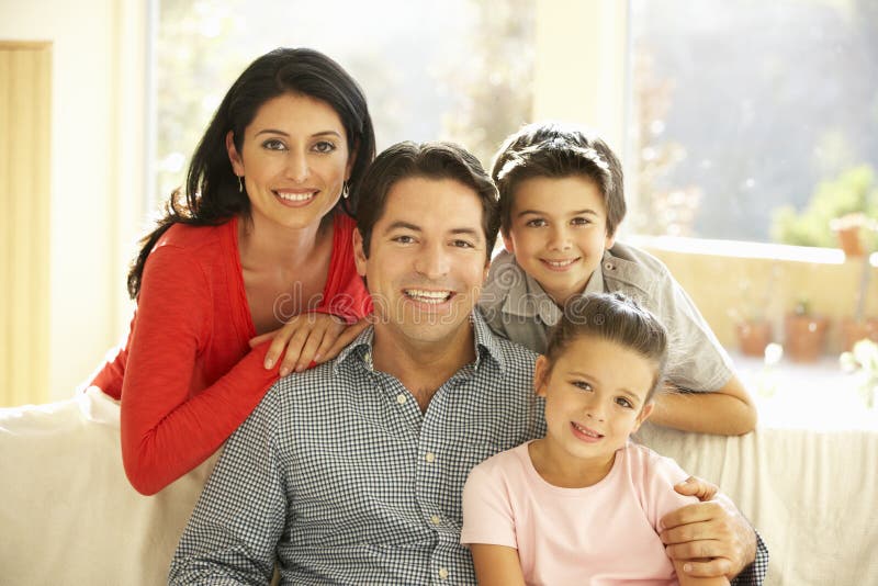 Giovane famiglia ispana che si rilassa su Sofa At Home immagini stock Giovane famiglia ispana che si rilassa su Sofa At Home immagini stock