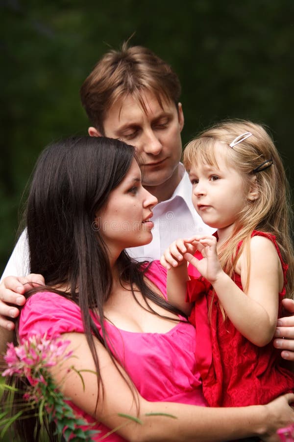Giovane famiglia nel giardino di estate. immagini stock libere da diritti Giovane famiglia nel giardino di estate. immagini stock libere da diritti