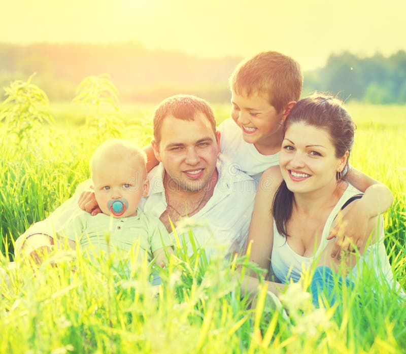 Giovane famiglia nel parco di estate fotografia stock libera da diritti Giovane famiglia nel parco di estate fotografia stock libera da diritti