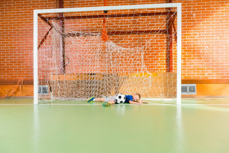 Giovane immersione subacquea del portiere per conservare la palla fotografia stock Giovane immersione subacquea del portiere per conservare la palla fotografia stock