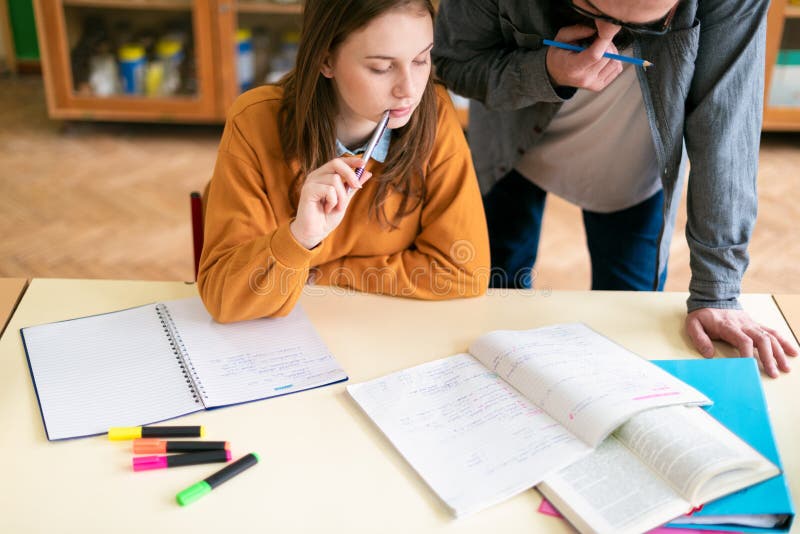 Giovane insegnante ispanico maschio che aiuta il suo studente nella classe di chimica Istruzione, ripetizioni fotografia stock libera da diritti