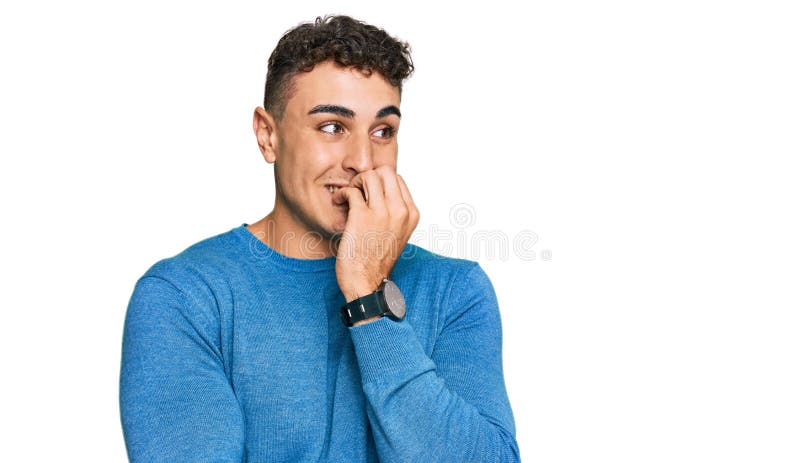 Giovane ispanico con abiti casuali apparentemente stressati e nervosi con le mani sulla bocca delle unghie morse fotografia stock