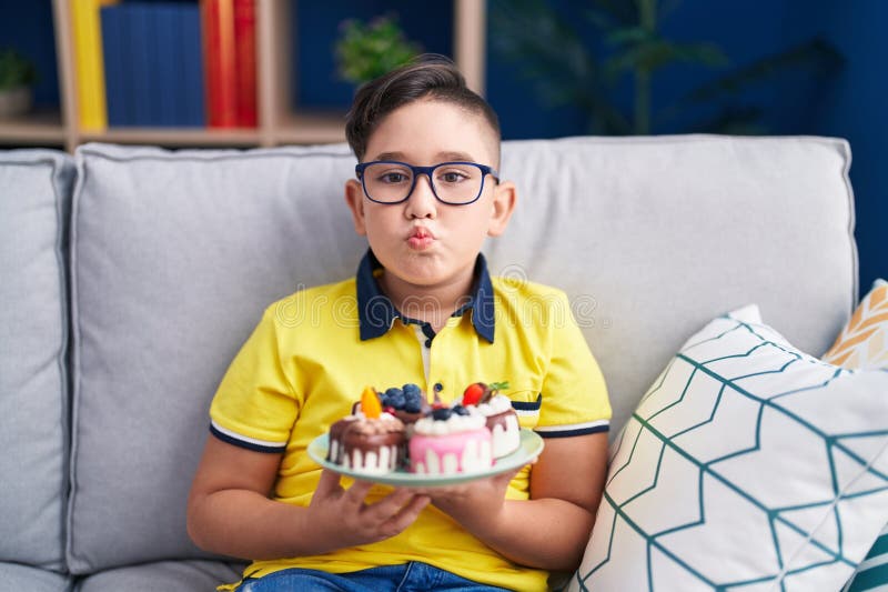Giovane ispanico con dolci per torte che guardano la macchina fotografica e un bacio bello e sexy fotografie stock libere da diritti