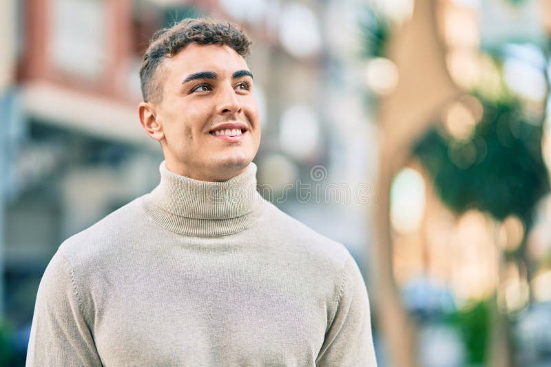 Giovane ispanico sorridente felice di essere in città fotografia stock