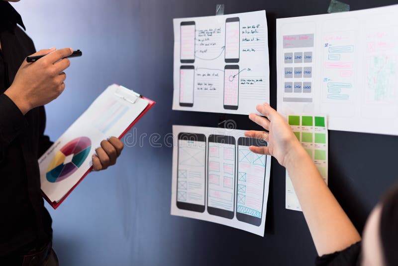 Giovane lavoro di squadra dei progettisti che lavora con lo sviluppo rispondente mobile del sito Web dei campioni di colore con U fotografie stock libere da diritti Giovane lavoro di squadra dei progettisti che lavora con lo sviluppo rispondente mobile del sito Web dei campioni di colore con U fotografie stock libere da diritti