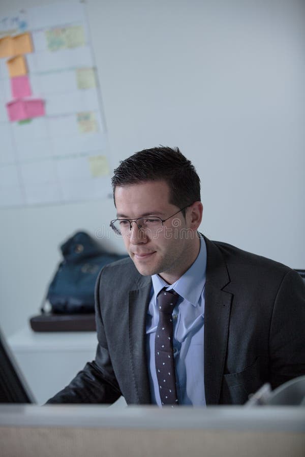 Giovane lavoro felice dell'uomo di affari in ufficio moderno Uomo d'affari bello In Office Bussinesmen reali dell'economista, non fotografia stock libera da diritti Giovane lavoro felice dell'uomo di affari in ufficio moderno Uomo d'affari bello In Office Bussinesmen reali dell'economista, non fotografia stock libera da diritti