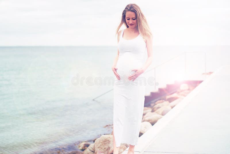 Giovane legame della donna incinta con il suo bambino futuro fotografia stock libera da diritti Giovane legame della donna incinta con il suo bambino futuro fotografia stock libera da diritti