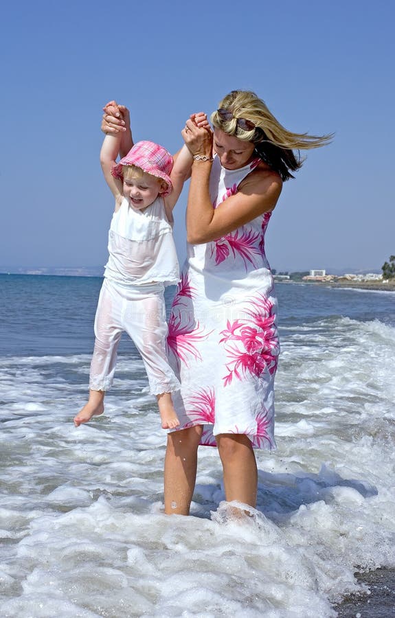 Giovane madre e figlia che giocano nel mare fotografie stock libere da diritti