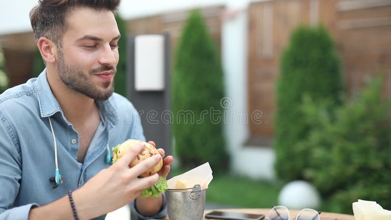 giovane mangiatore di uomini casuale un hamburger al ristorante