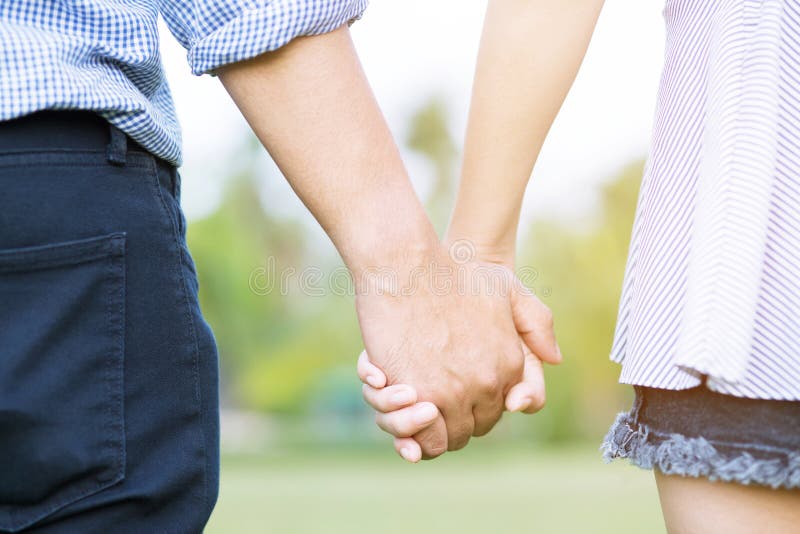 Giovane manifestazione dell'amante delle coppie che si tiene per mano per fare cuore immagine stock