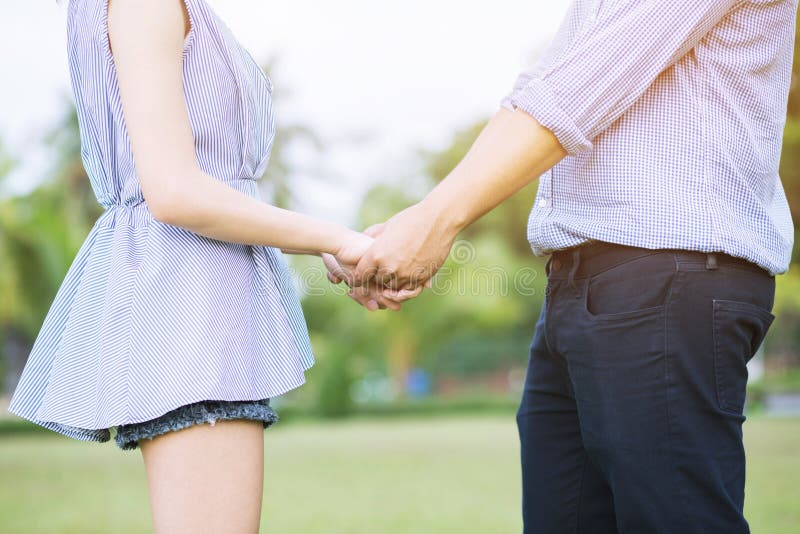Giovane manifestazione dell'amante delle coppie che si tiene per mano per fare cuore immagine stock