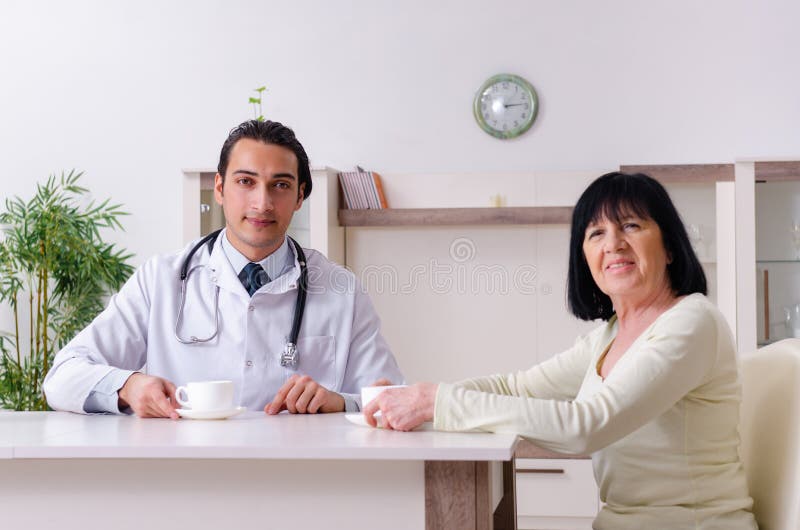 Giovane medico che esamina donna anziana senior immagine stock libera da diritti Giovane medico che esamina donna anziana senior immagine stock libera da diritti