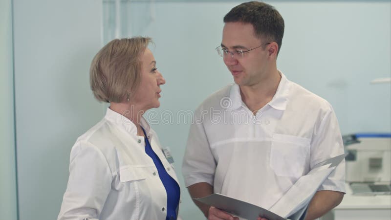 Giovane medico maschio e anziana donna che discute di un caso medico