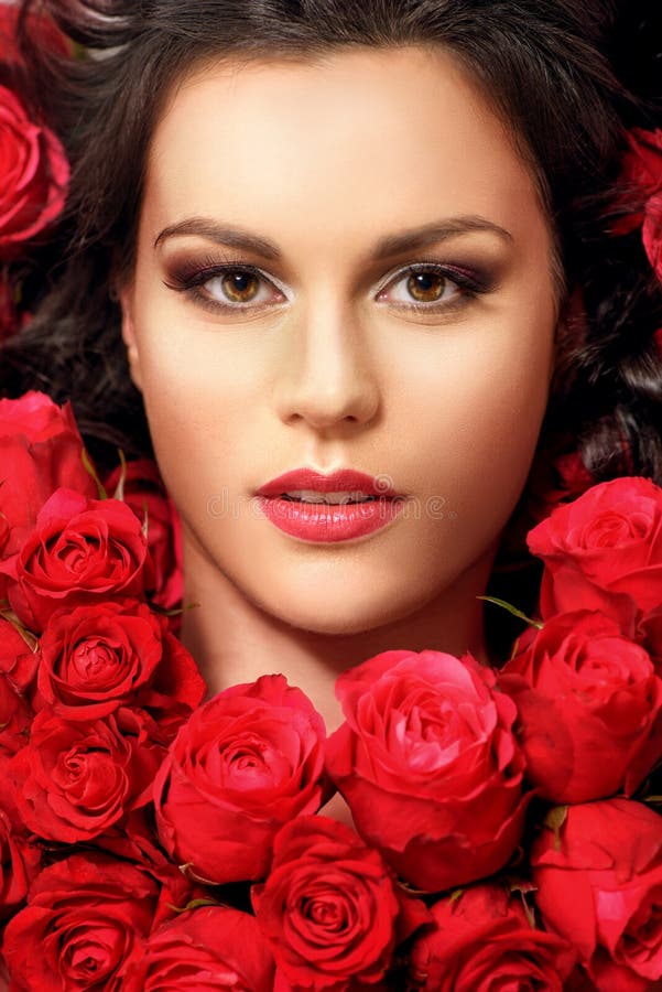 Giovane menzogne di modello nelle rose rosse immagine stock libera da diritti