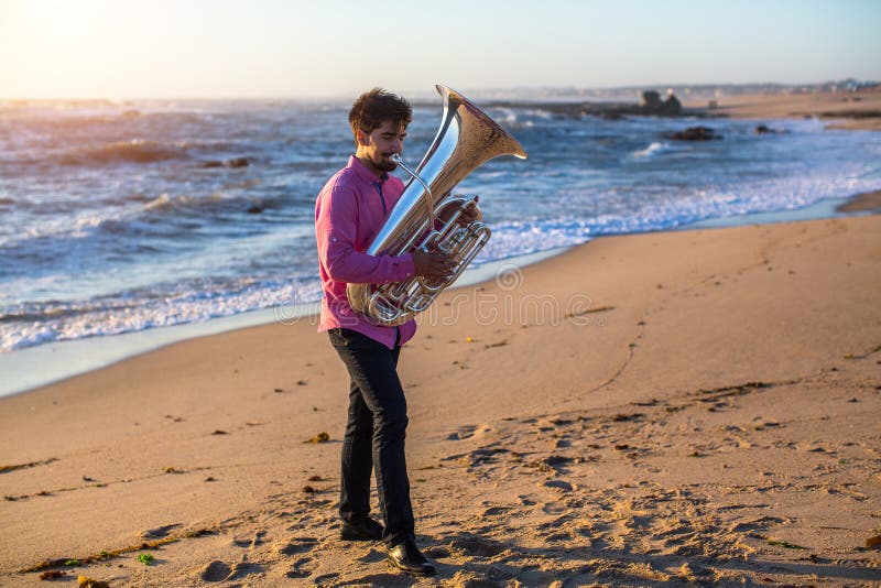 Giovane musicista maschio che gioca tromba sulla costa immagine stock libera da diritti Giovane musicista maschio che gioca tromba sulla costa immagine stock libera da diritti