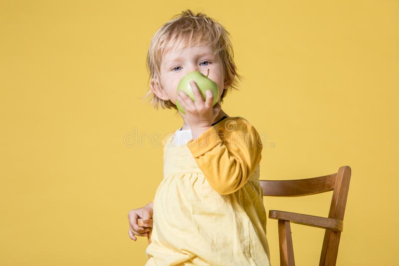 Giovane neonata in vestito giallo su fondo giallo fotografie stock libere da diritti Giovane neonata in vestito giallo su fondo giallo fotografie stock libere da diritti