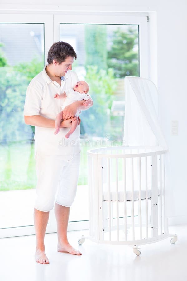 Giovane padre che tiene il suo neonato accanto alla greppia immagini stock libere da diritti Giovane padre che tiene il suo neonato accanto alla greppia immagini stock libere da diritti