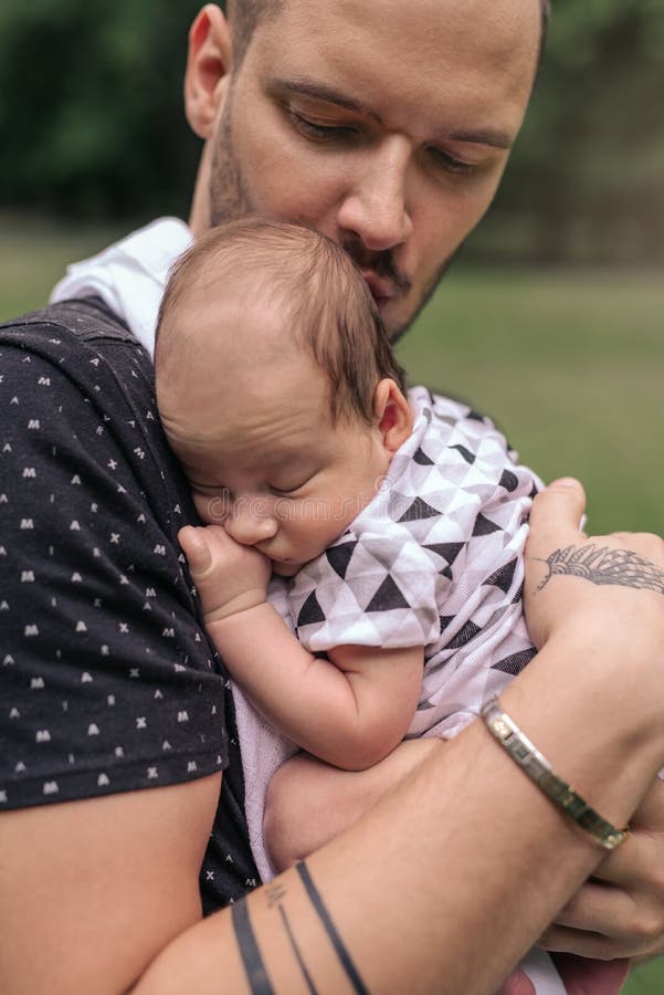 Giovane padre preoccupantesi che culla il suo neonato adorabile fuori immagine stock libera da diritti