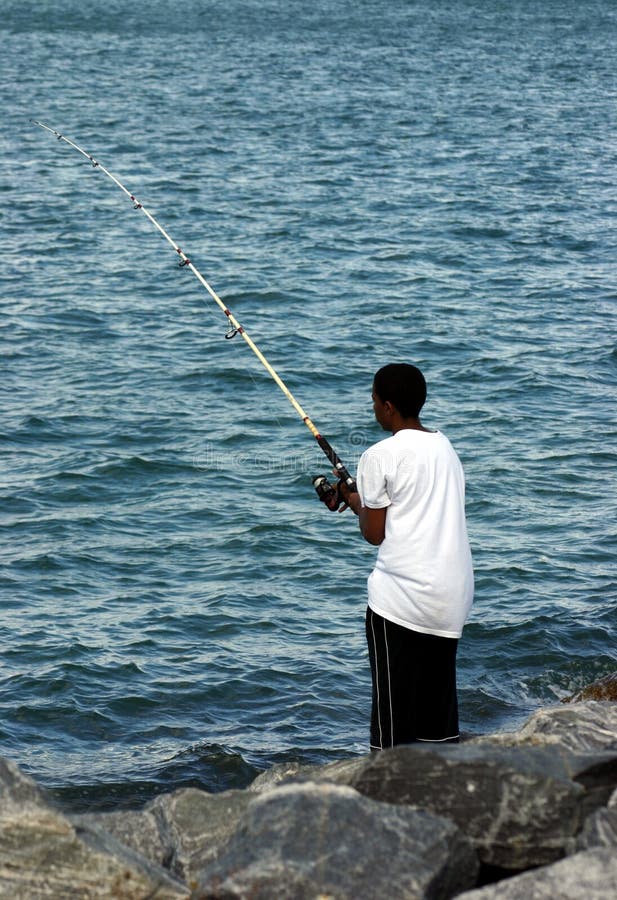 Giovane pesca dell'uomo di colore fotografia stock libera da diritti Giovane pesca dell'uomo di colore fotografia stock libera da diritti