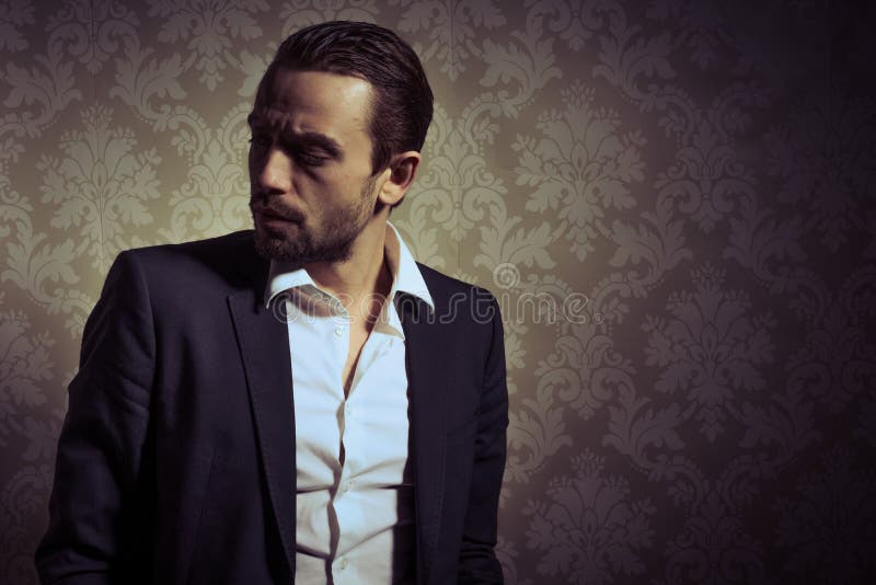 Giovane posa bella ed elegante dell'uomo isolata sopra fondo d'annata fotografia stock Giovane posa bella ed elegante dell'uomo isolata sopra fondo d'annata fotografia stock