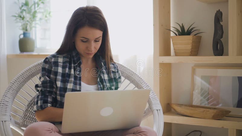 Giovane progettista femminile in camicia del controllo che lavora al nuovo di zecca computer portatile