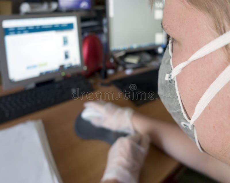 Giovane programmatore maschile che lavora al computer con una maschera protettiva e guanti fotografia stock