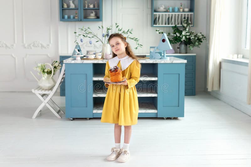 Giovane ragazza carina con la torta di Pasqua in mano. Sorridete i pasticcini di pasqua che tengono bambini immagine stock