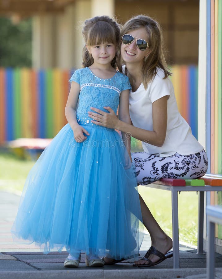 Giovane ragazza prescolare graziosa sorridente bionda esile della figlia degli abbracci della madre, di zia o della sorella picco fotografia stock Giovane ragazza prescolare graziosa sorridente bionda esile della figlia degli abbracci della madre, di zia o della sorella picco fotografia stock