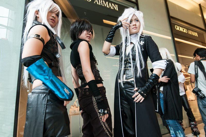 Giovane ragazza tailandese tre che posa per un photogrpher durante il festival di cosplay davanti a Siam Pagagon, Bangkok fotografia stock Giovane ragazza tailandese tre che posa per un photogrpher durante il festival di cosplay davanti a Siam Pagagon, Bangkok fotografia stock