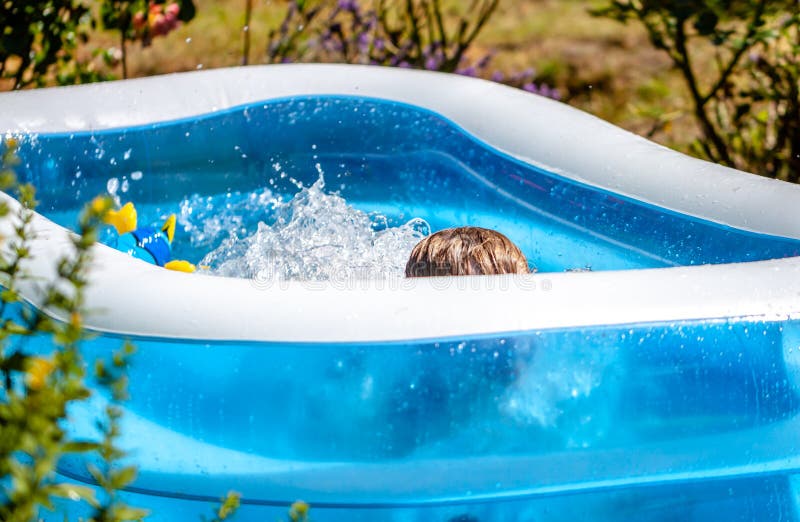 Giovane ragazzo che annega nella piscina di estate fotografie stock Giovane ragazzo che annega nella piscina di estate fotografie stock