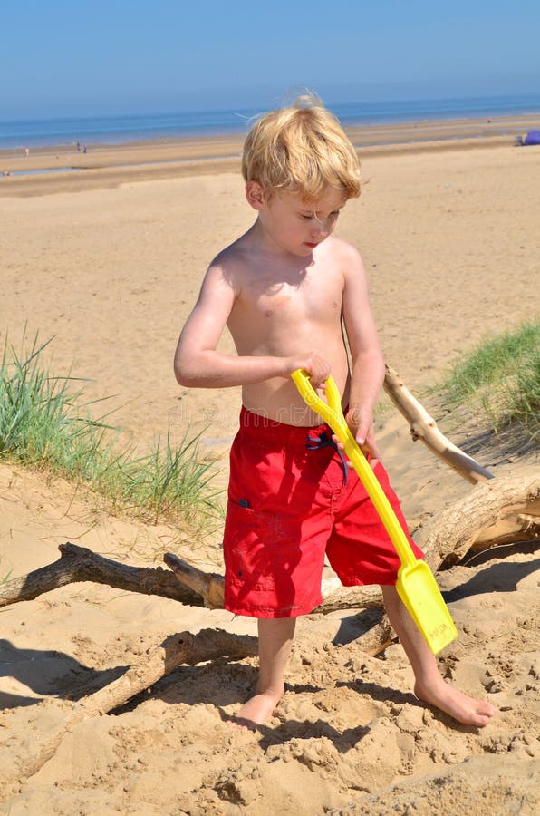 Giovane ragazzo sulla spiaggia immagine stock Giovane ragazzo sulla spiaggia immagine stock