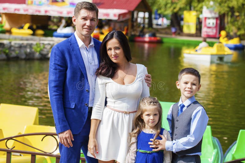 Giovane ritratto felice della famiglia su fondo del parco di autunno fotografia stock Giovane ritratto felice della famiglia su fondo del parco di autunno fotografia stock