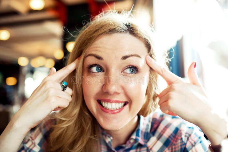 Giovane riuscito sorridere femminile astuto con la sua testa vicina delle mani fotografie stock libere da diritti Giovane riuscito sorridere femminile astuto con la sua testa vicina delle mani fotografie stock libere da diritti