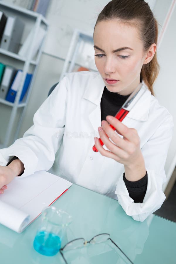 Giovane scienziato femminile che controlla sangue in tubo immagini stock libere da diritti Giovane scienziato femminile che controlla sangue in tubo immagini stock libere da diritti