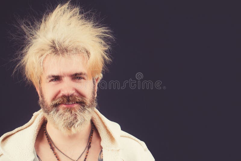 Goofy young man, with full beard and moustache and wild hair, pull a comical face to the camera. Space for your text. Goofy young man, with full beard and moustache and wild hair, pull a comical face to the camera. Space for your text