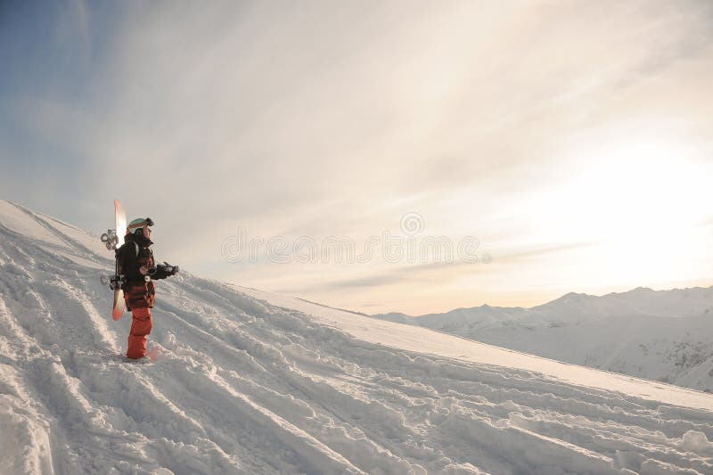 Giovane snowboarder che sta sulla neve della montagna fotografia stock Giovane snowboarder che sta sulla neve della montagna fotografia stock