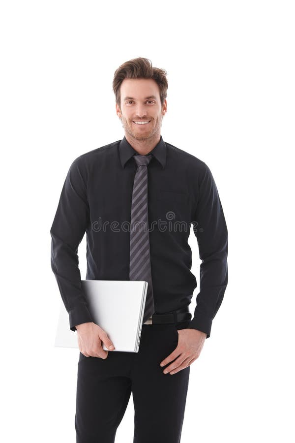 Giovane sorridere del computer portatile della holding dell'uomo d'affari immagine stock