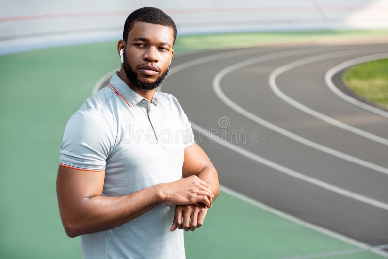 Giovane sportivo bello premuroso che esamina la distanza fotografia stock libera da diritti Giovane sportivo bello premuroso che esamina la distanza fotografia stock libera da diritti