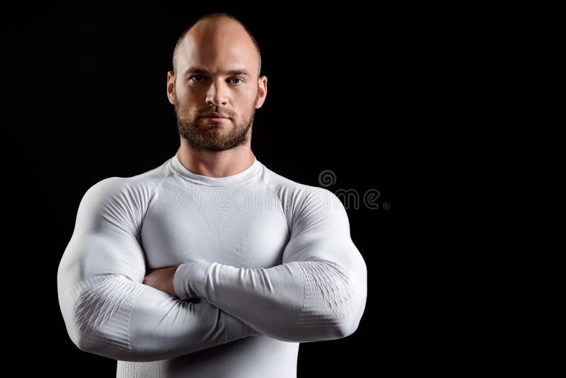Giovane sportivo potente in abbigliamento bianco sopra fondo nero fotografia stock Giovane sportivo potente in abbigliamento bianco sopra fondo nero fotografia stock