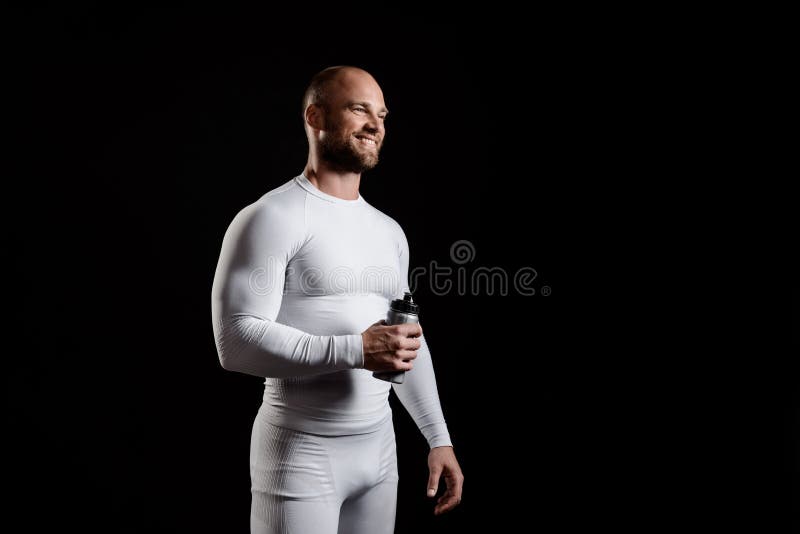 Giovane sportivo potente in abbigliamento bianco sopra fondo nero immagini stock libere da diritti Giovane sportivo potente in abbigliamento bianco sopra fondo nero immagini stock libere da diritti