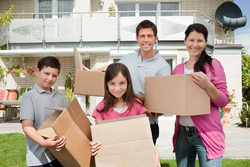 Giovane spostamento della famiglia nella nuova casa fotografia stock Giovane spostamento della famiglia nella nuova casa fotografia stock